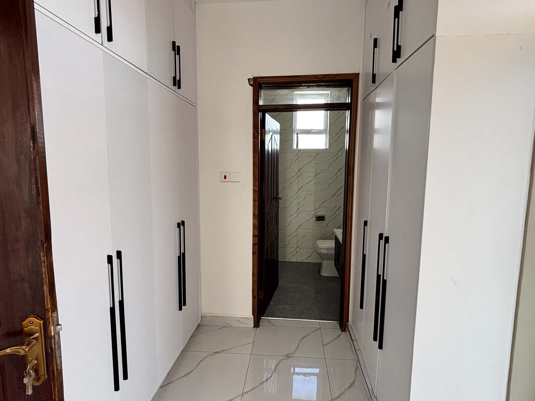Fitted wardrobes leading to an ensuite bathroom
