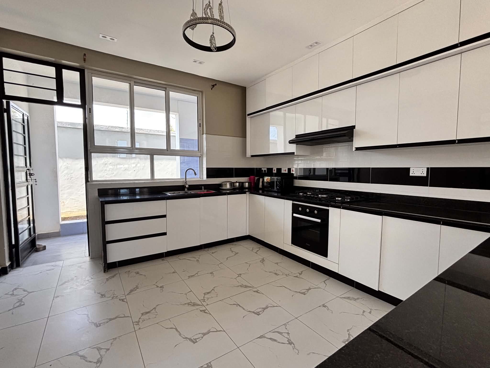 Modern fitted kitchen with dark countertops and white cabinetry