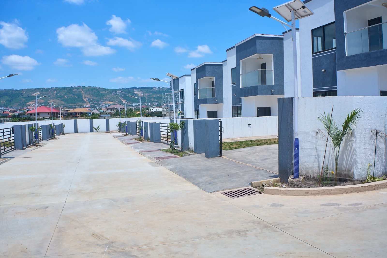 Villas along the paved main drive with hills beyond