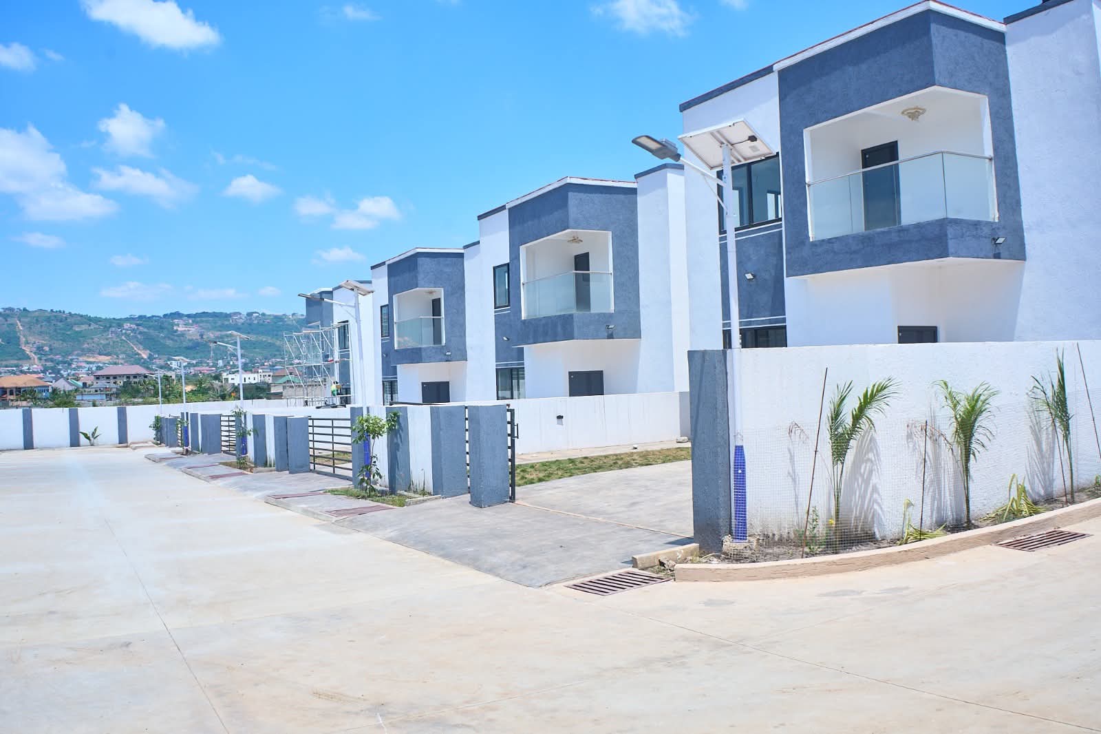 Row of villas with glass balconies and hills in the distance
